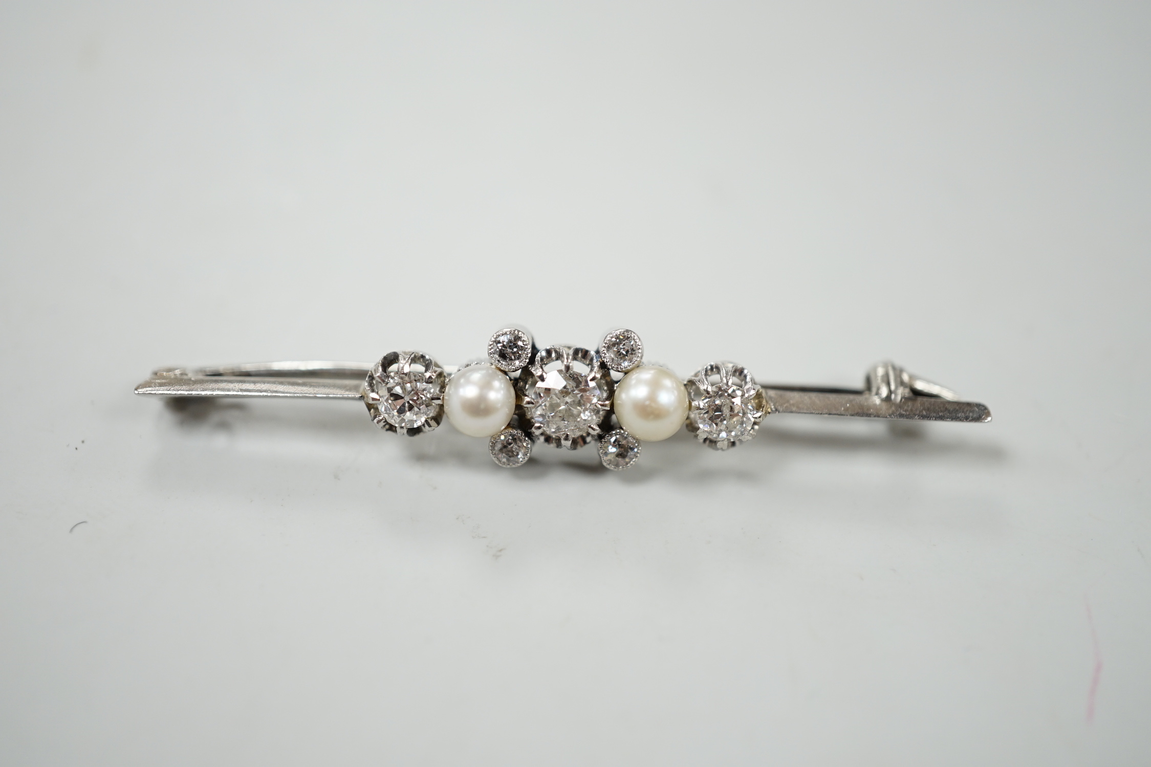 A white metal, diamond and cultured pearl cluster set bar brooch, 52mm, gross weight 6.2 grams.